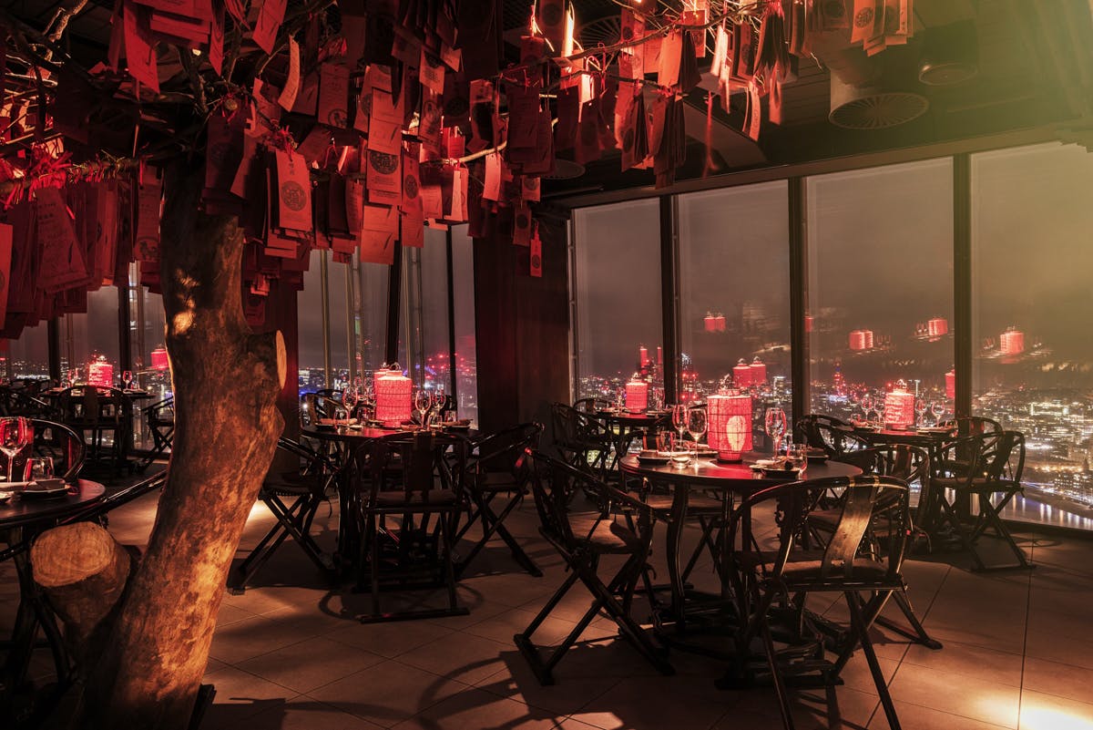 Stylish Beijing Hutong dining venue with red-decorated tree, ideal for events.