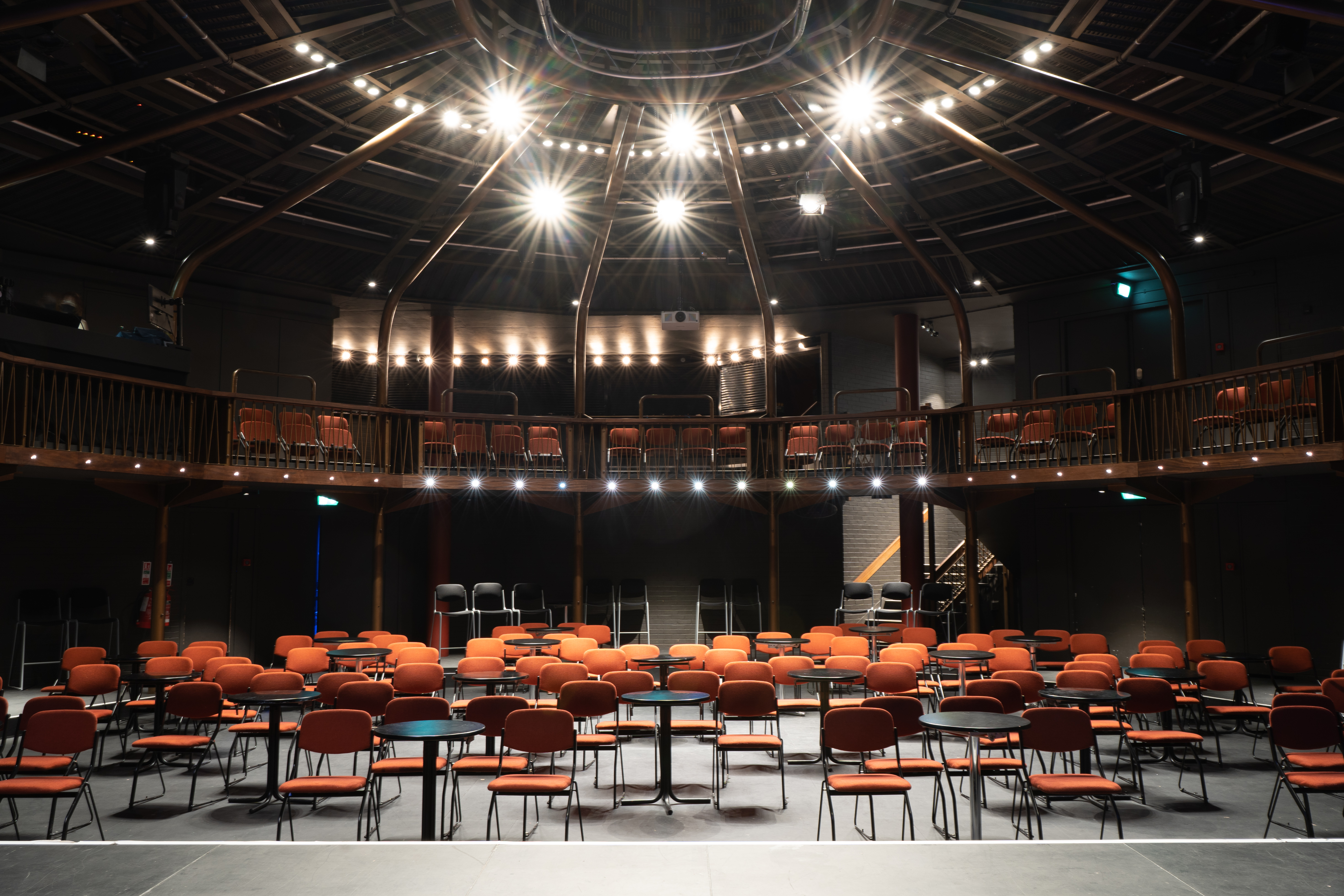 Theatre in The Albany with vibrant orange chairs for engaging events and presentations. - Banner
