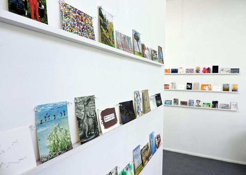 Art Hub Gallery display with vibrant artworks on white shelves for creative networking events.