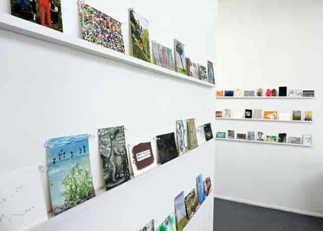 Art Hub Gallery display with vibrant artworks on white shelves for creative networking events.