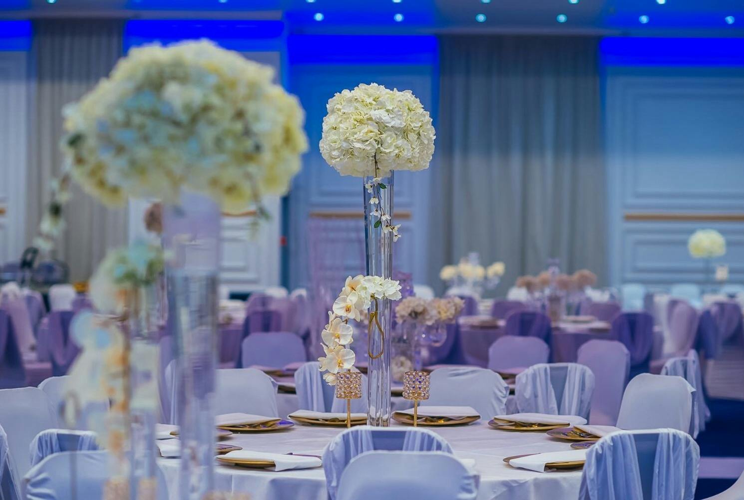 Elegant event space in The Coliseum Suite with tall floral centerpieces for weddings and corporate events.