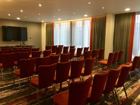 Hogarth Suite meeting room with orange chairs, ideal for presentations and workshops.