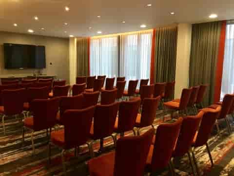 Hogarth Suite meeting room with orange chairs, perfect for presentations and workshops.