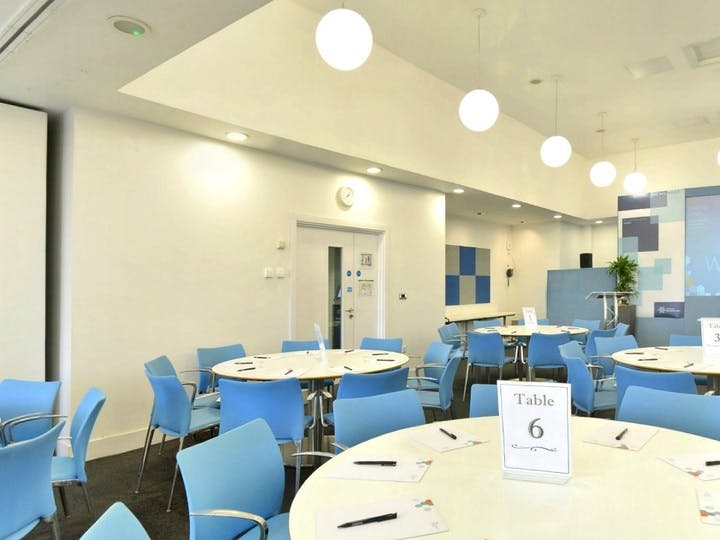 Modern Maslow Suite with round tables, ideal for workshops and meetings.