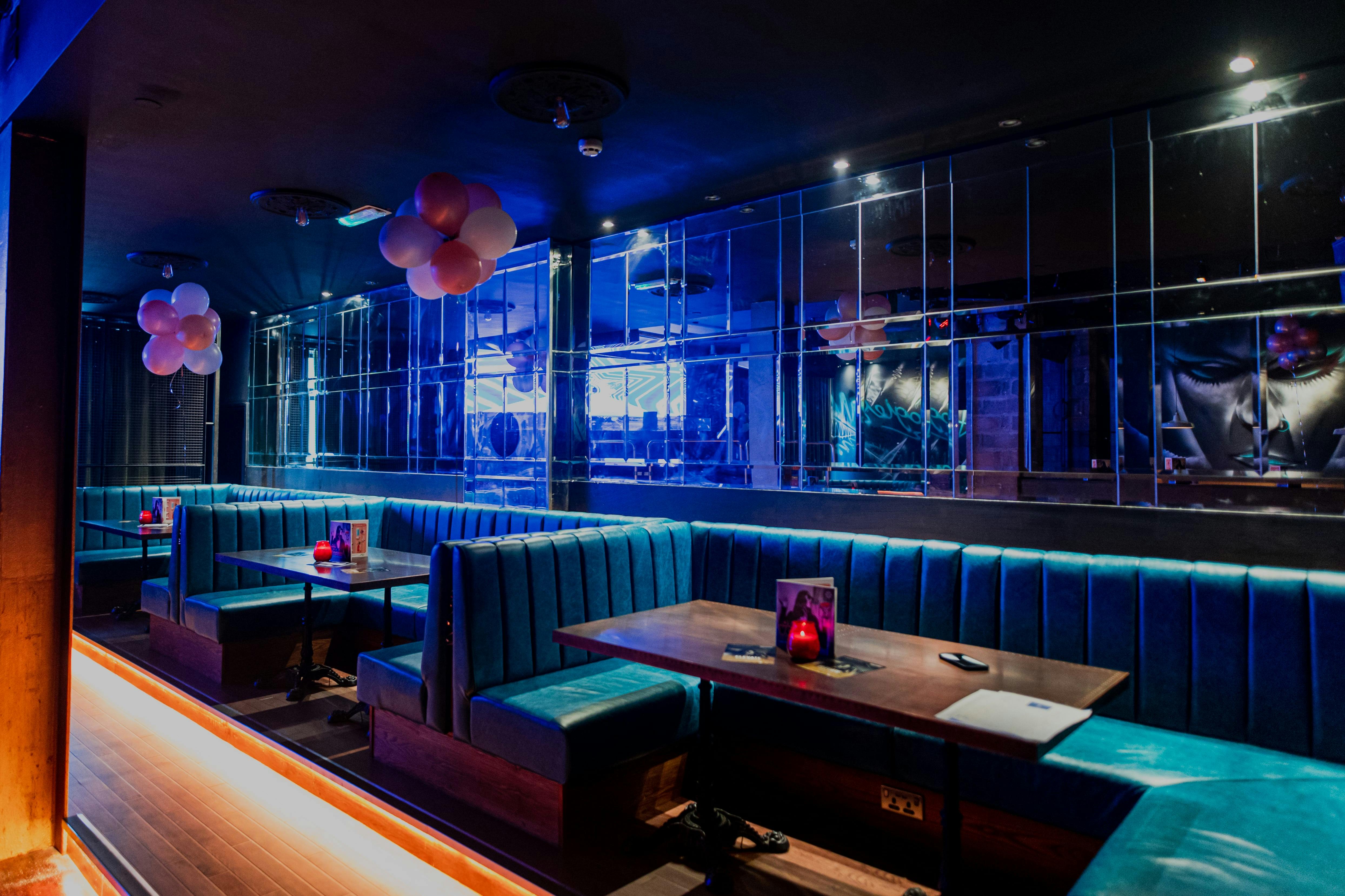 Stylish event space in Revolution Cardiff with plush blue seating and ambient lighting.