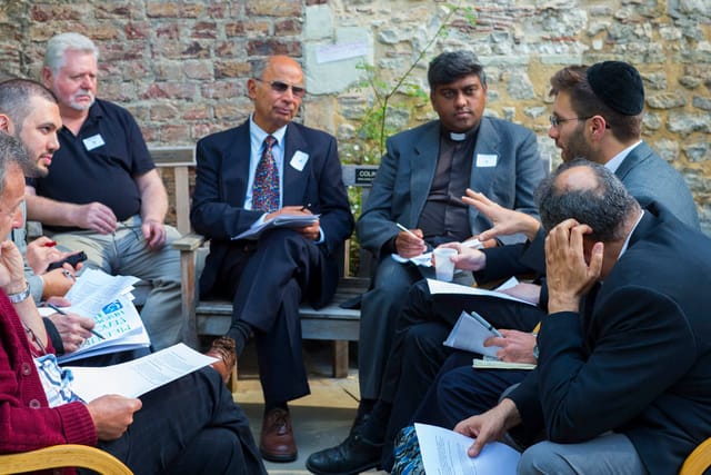 Group brainstorming session at The Tent, diverse attendees with notepads, networking event.
