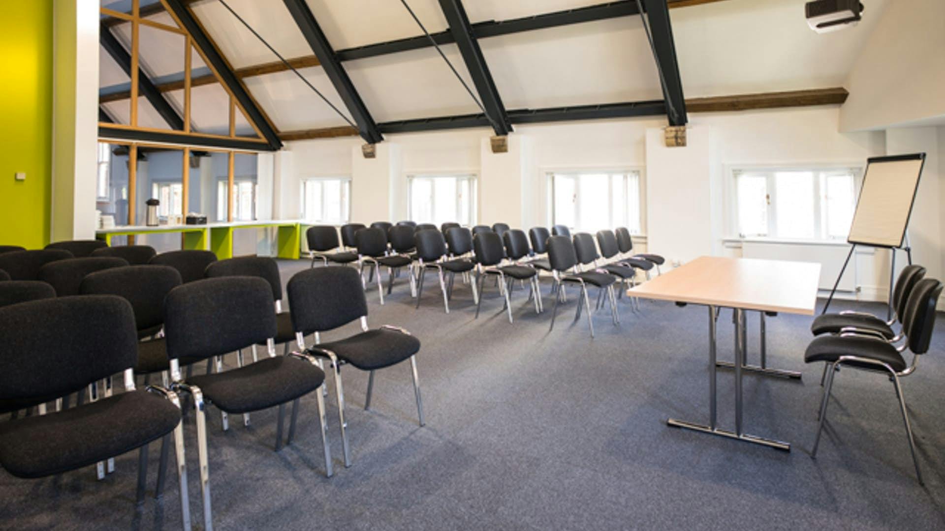 Versatile meeting space with high ceilings for workshops at Manchester Cathedral Visitor Centre.