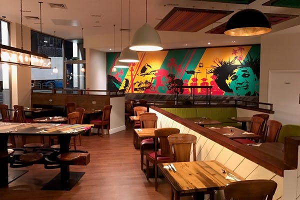 Vibrant Whole Restaurant with colorful mural, ideal for casual meetings and events.