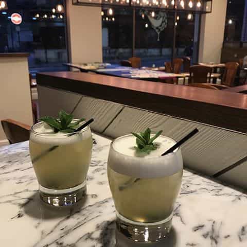 Elegant cocktails with mint garnish at Assenheims Bar & Grill for networking events.