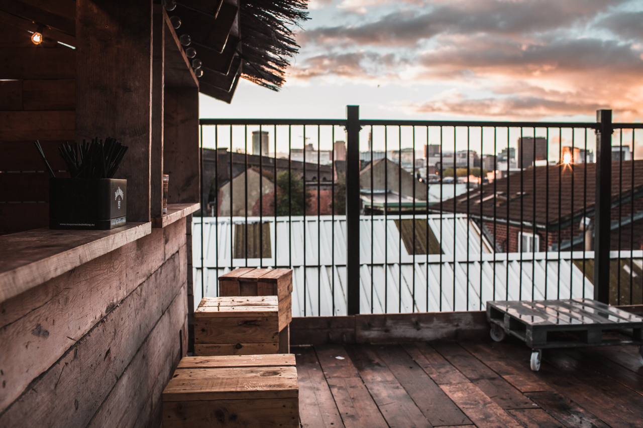 Stylish rooftop venue with wooden elements, ideal for networking events and sunset receptions.