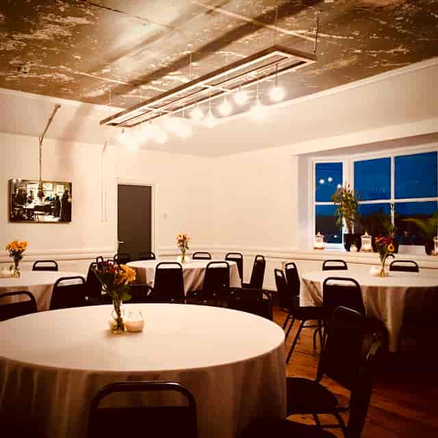 Versatile event space at Dovedale Towers with round tables and floral centerpieces.