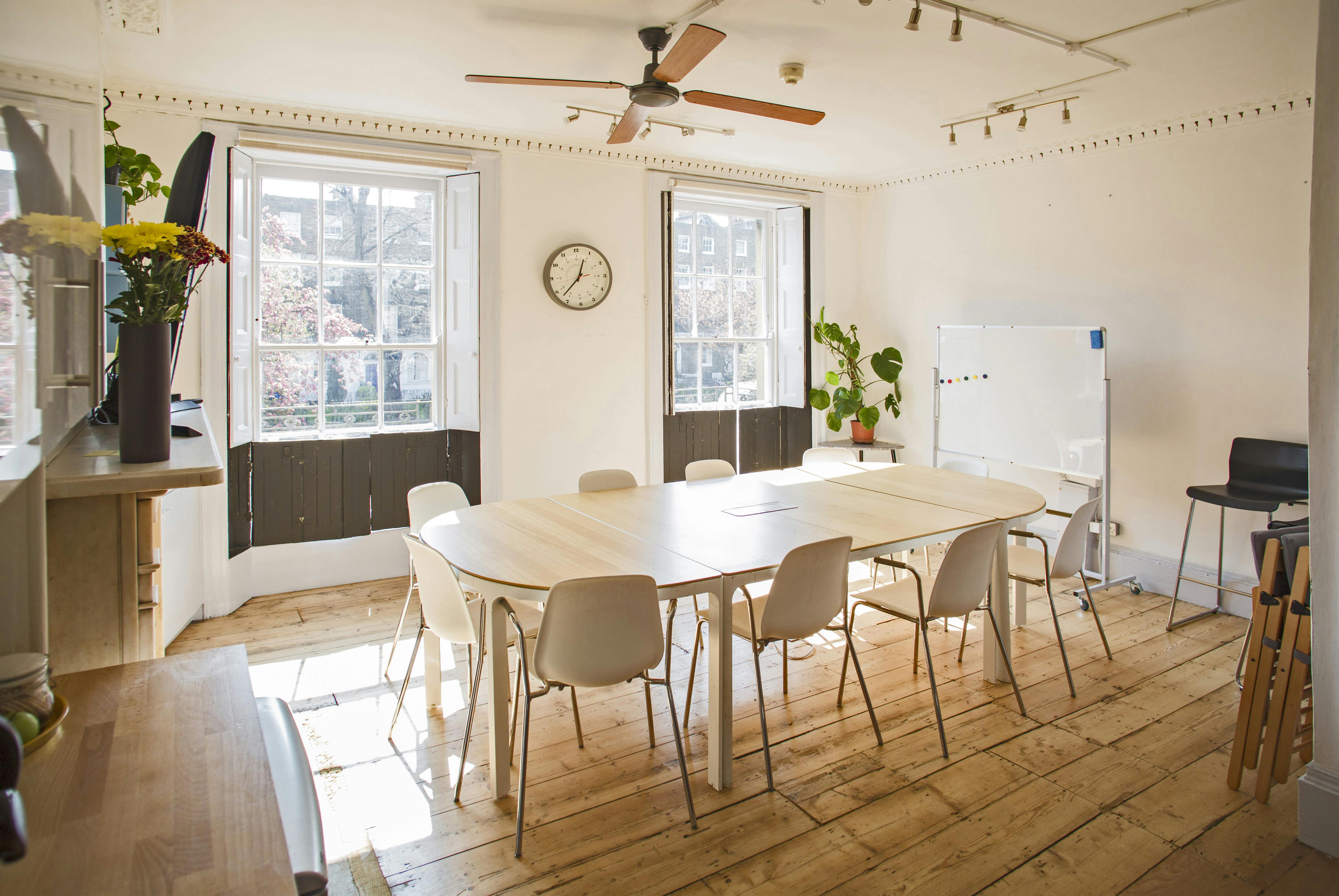 Bright meeting room with large table, ideal for workshops and collaborative sessions.