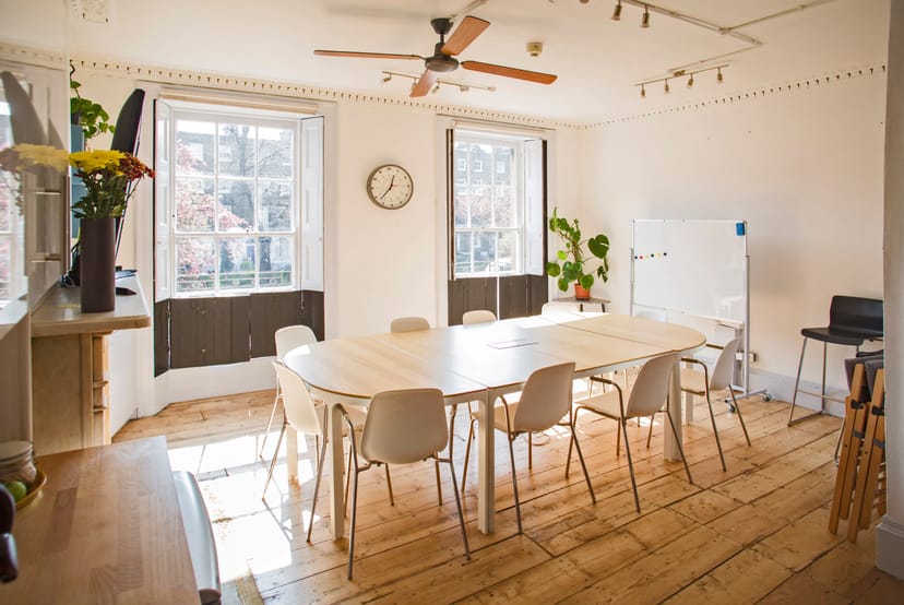 Bright meeting room with large table, ideal for workshops and collaborative sessions.