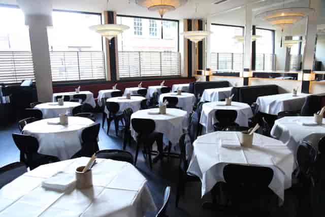 Private dining room with round tables at Alberts Club, ideal for events and gatherings.