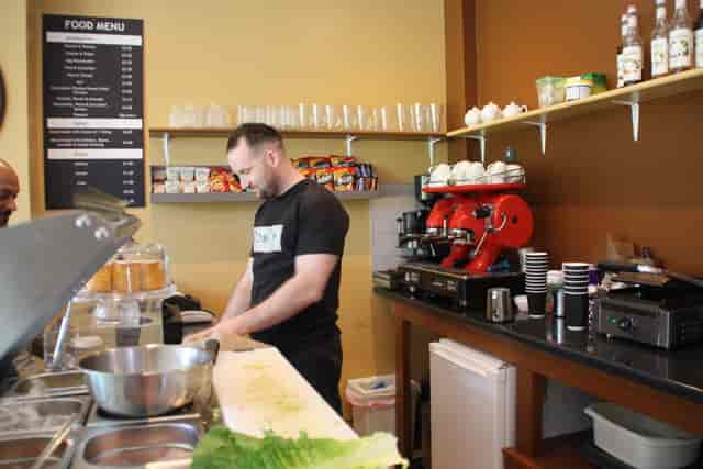 Bustling Rossi's Coffee Shop with barista preparing drinks for networking events.
