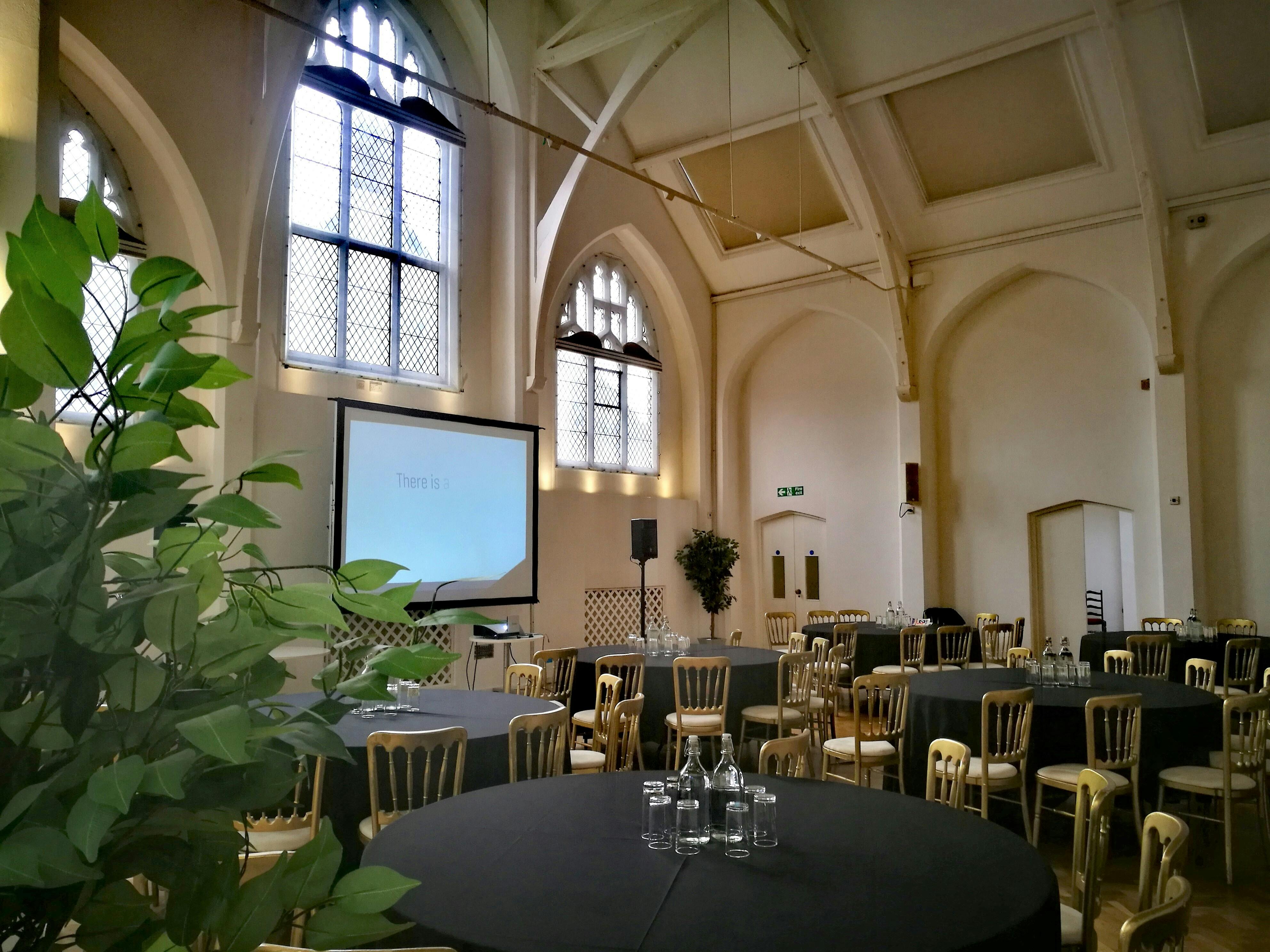 Exclusive Hire in The Old Library: elegant event space with round tables for meetings.