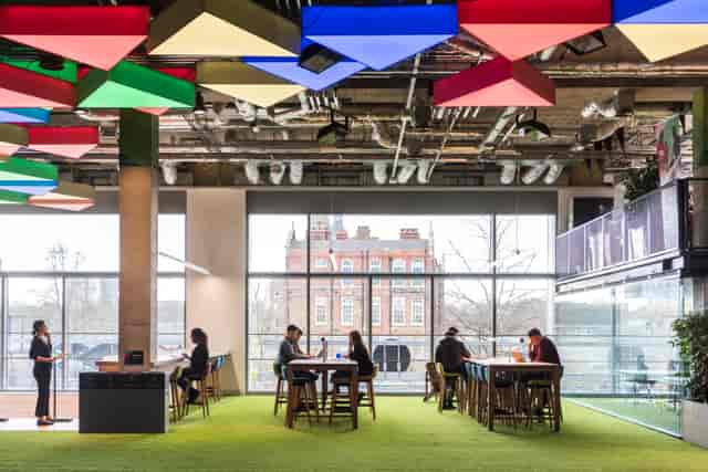 Modern flexible workspace with vibrant ceiling, ideal for meetings and gatherings.