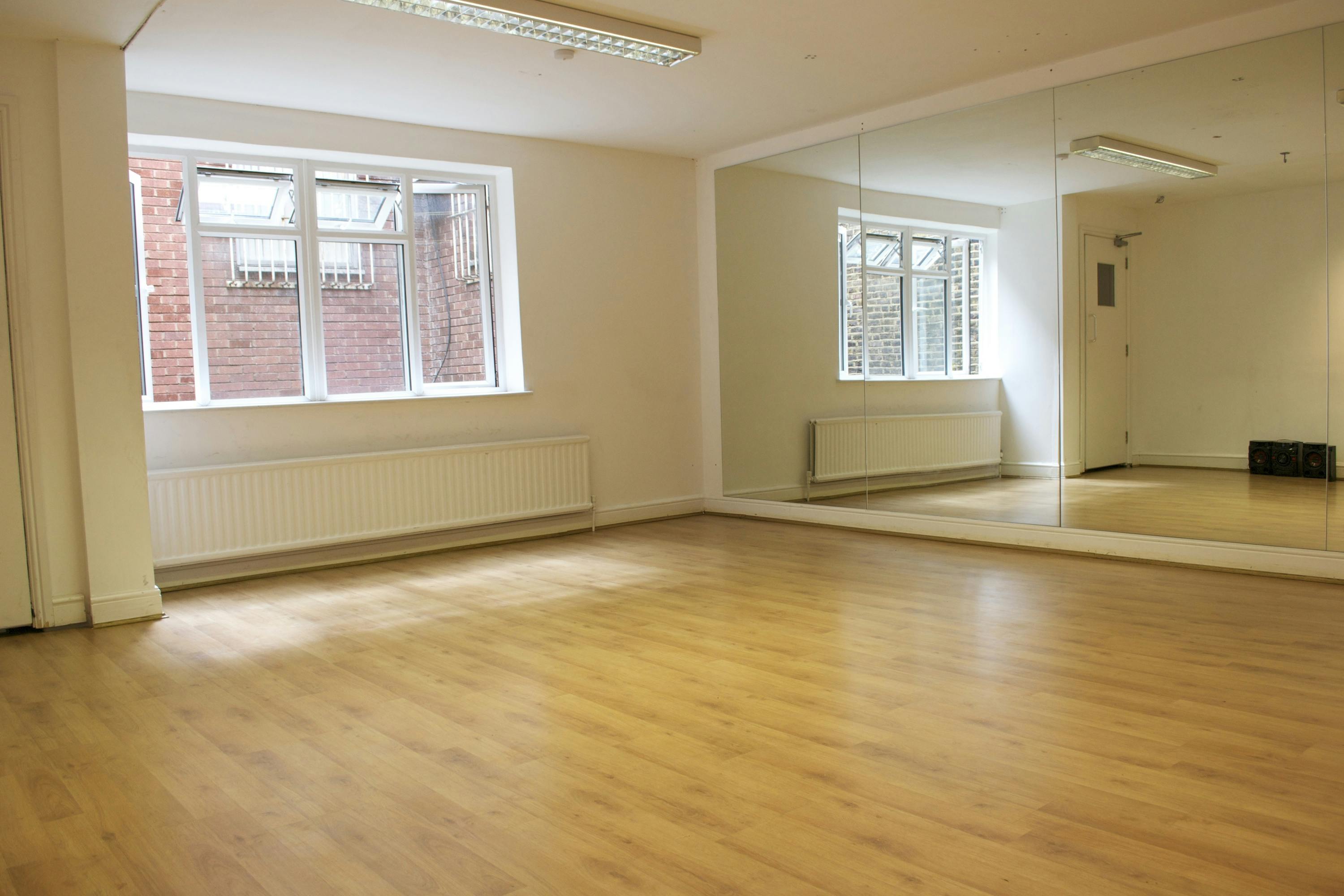 Versatile event space with wooden floors and natural light, perfect for workshops or meetings.