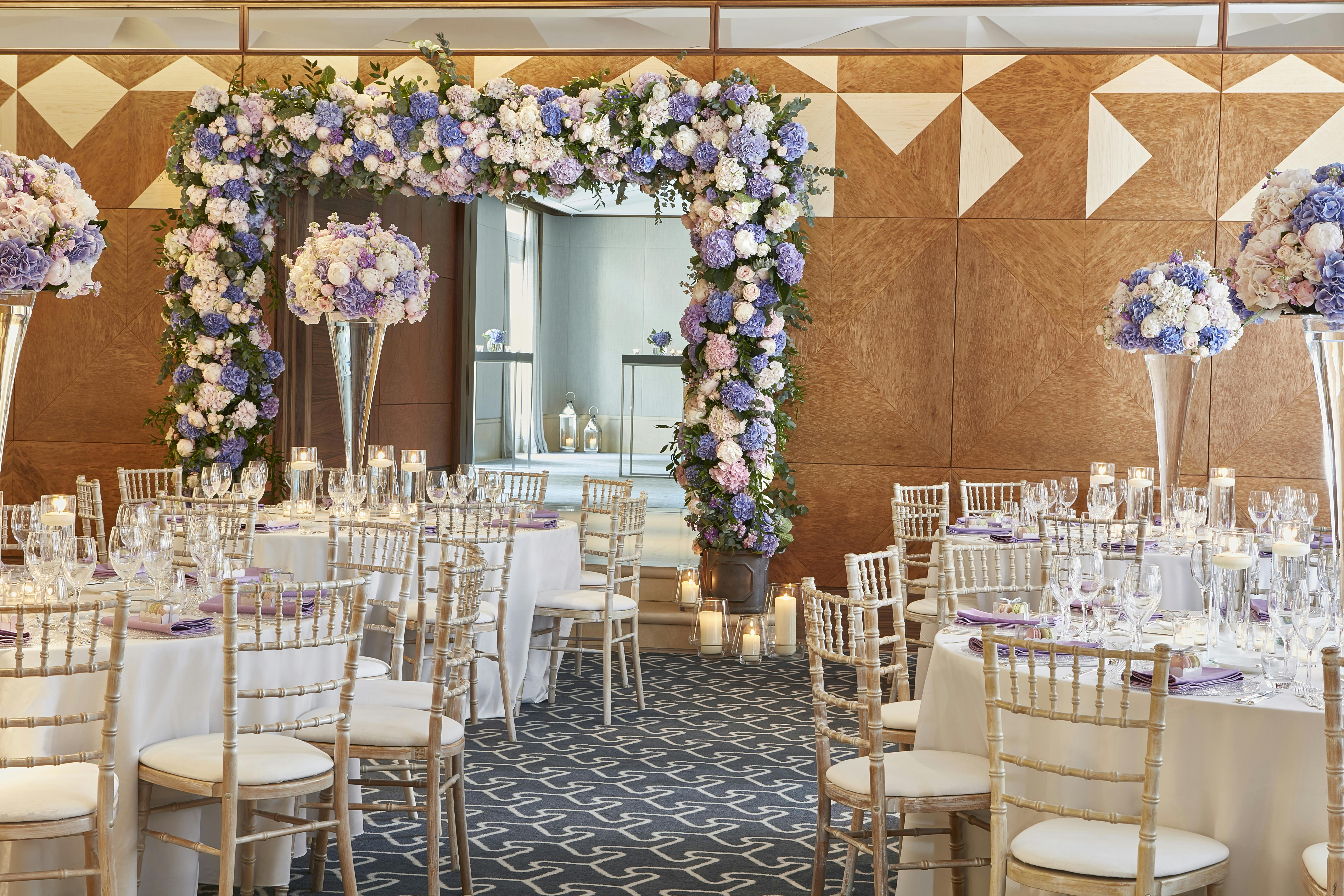 Elegant ballroom with floral arch, perfect for weddings and upscale events.