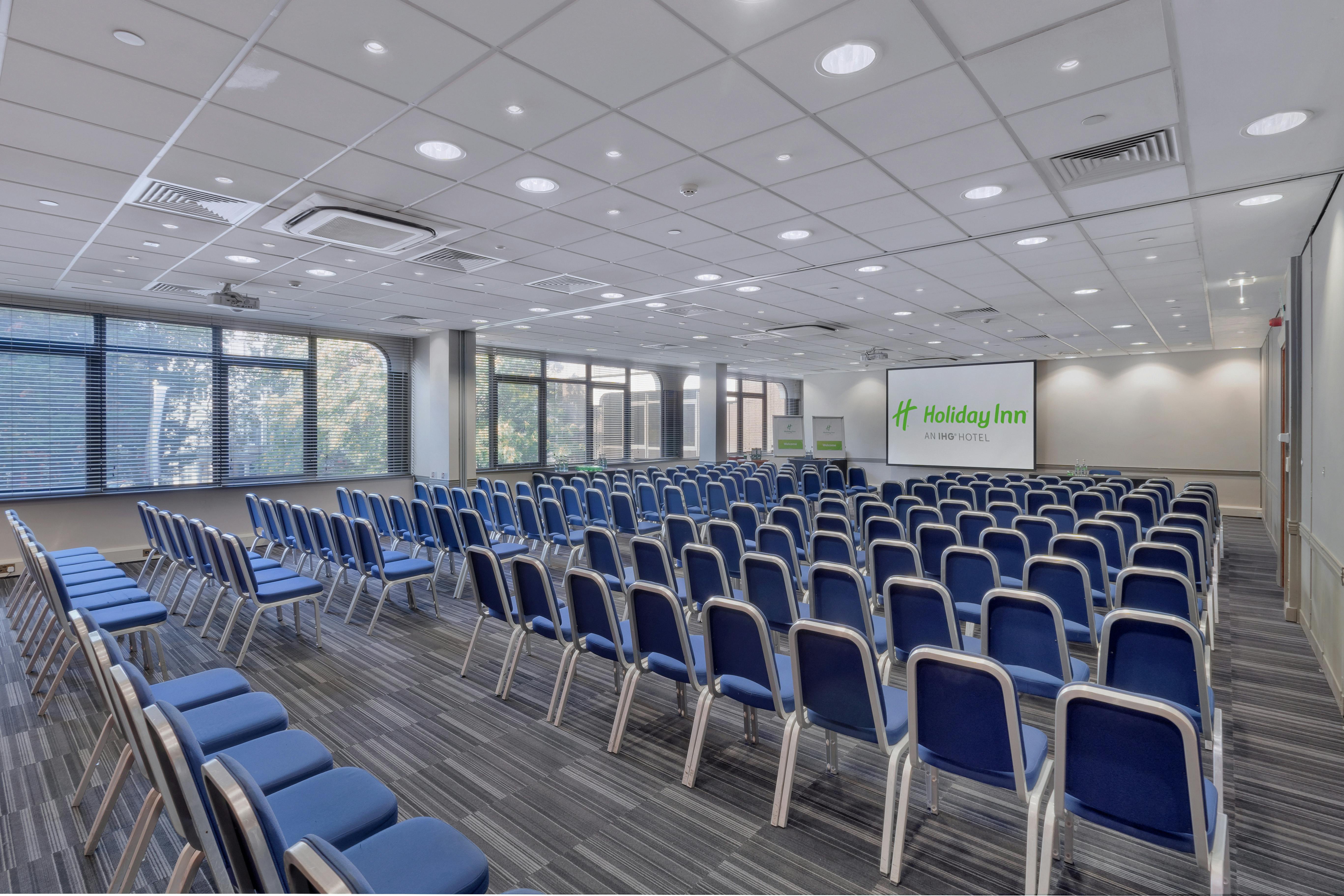 Meeting space with blue chairs at Holiday Inn London for conferences and seminars.