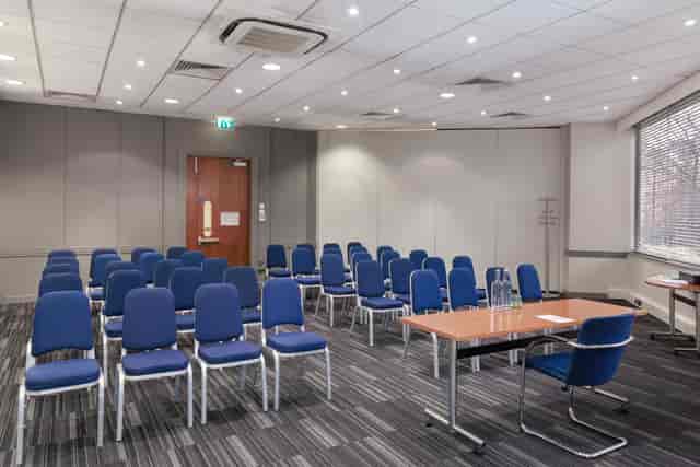 Madonna in a professional meeting room setup for a workshop at Holiday Inn Kensington.