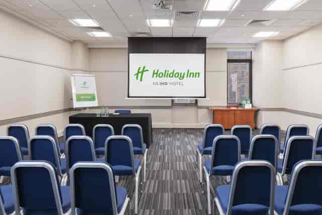 Meeting room at Holiday Inn London Kensington Forum with clear presentation screen.