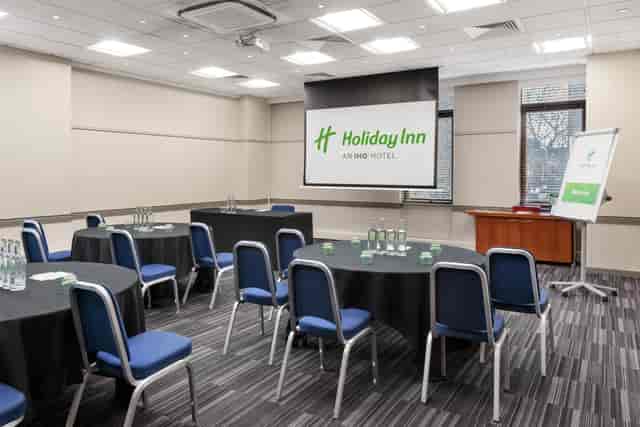 Meeting room at Holiday Inn Kensington with round tables for corporate events.