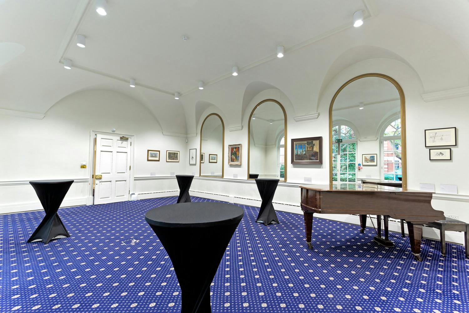 Elegant event space with arched windows and grand piano at The Solar Room & Garden.