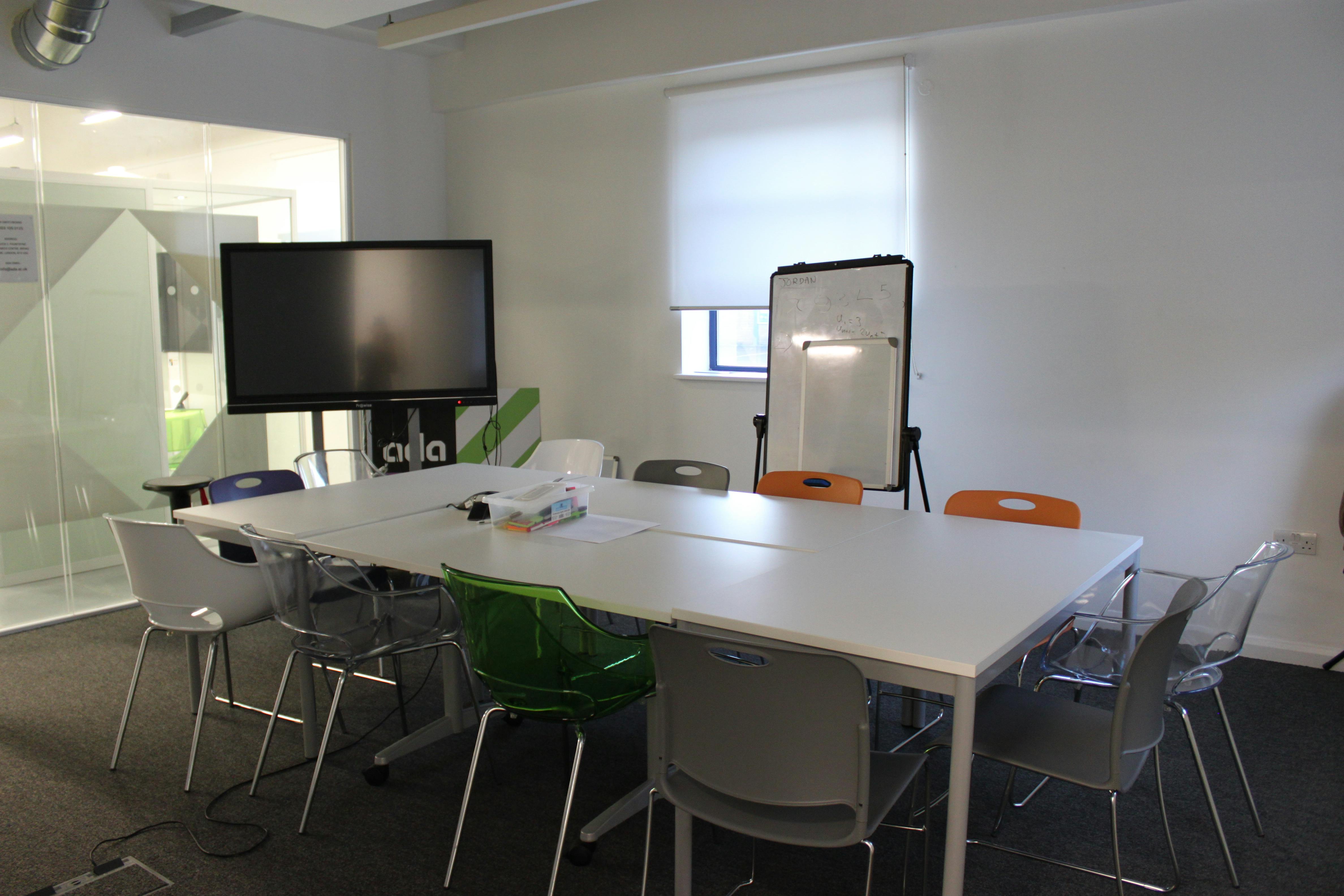 Modern boardroom with colorful chairs for meetings and workshops at Ada National College.