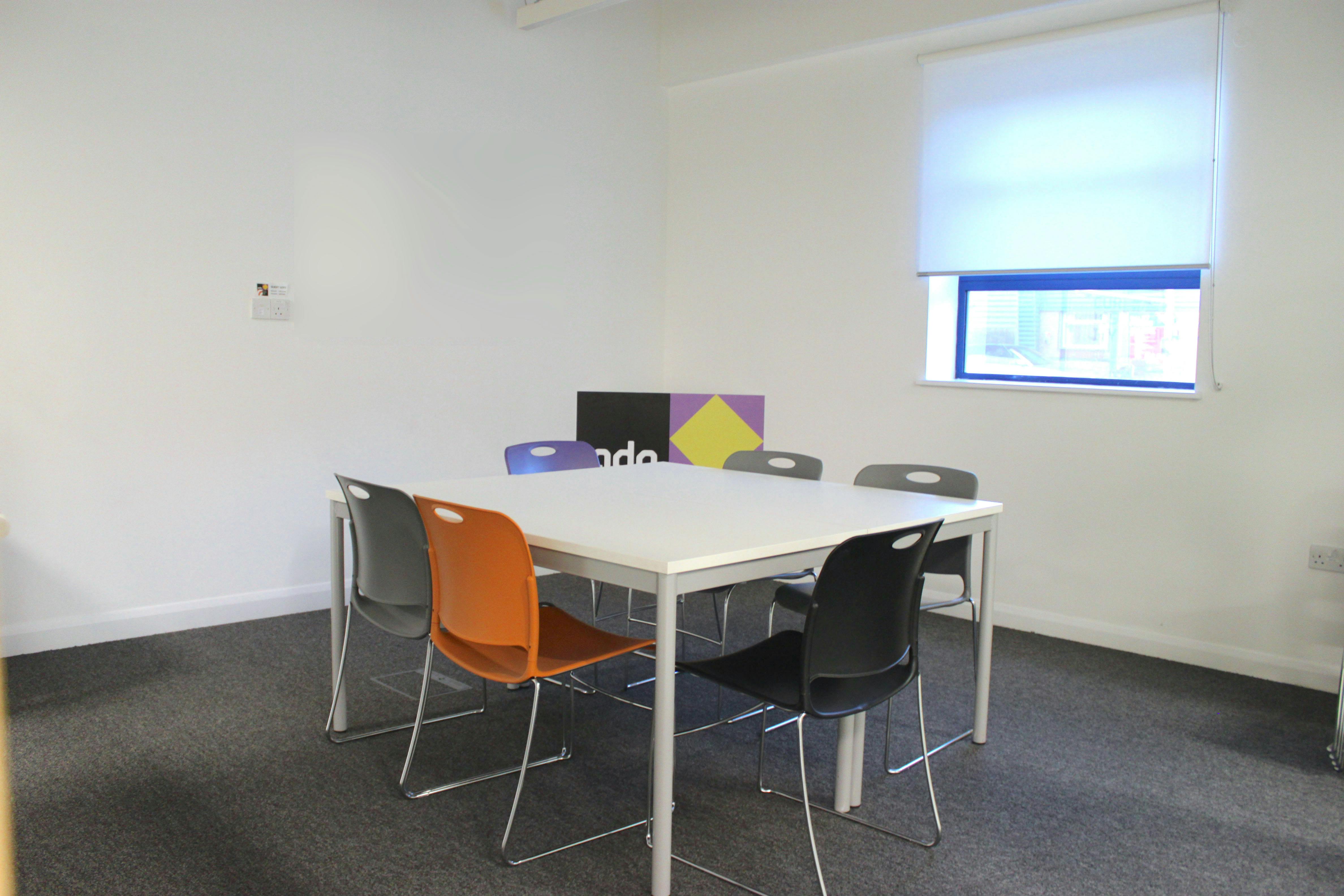 Ground Floor Meeting Room - Swift: minimalist setup with colorful chairs for collaborative events.