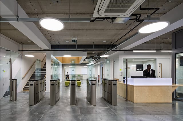 Modern reception area with glass barriers at Ada National College for corporate events.