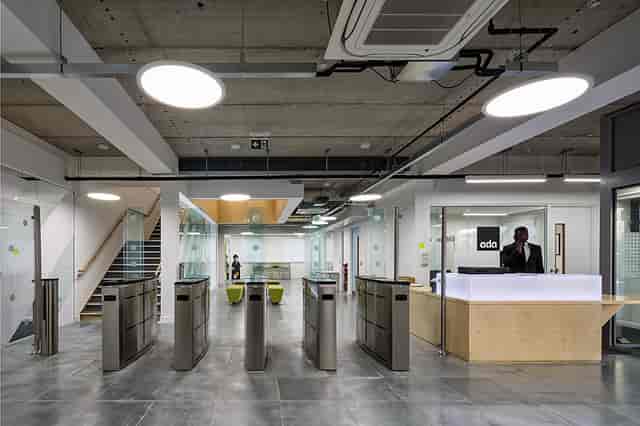Modern reception area with glass barriers at Ada National College for corporate events.