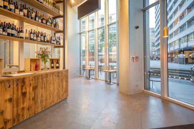 Modern venue with stylish bar and extensive wine display for networking events.