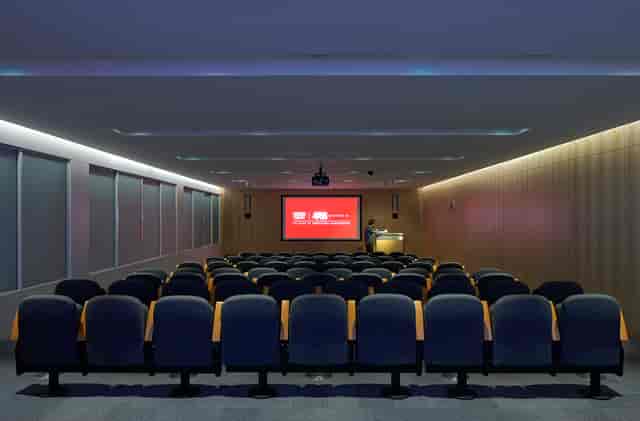 Auditorium conference room with tiered seating, ideal for meetings and presentations.