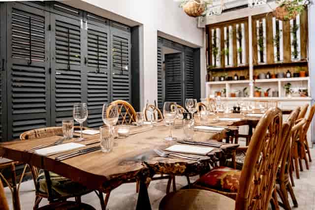 Private dining room with rustic table and rattan chairs for intimate events and meetings.