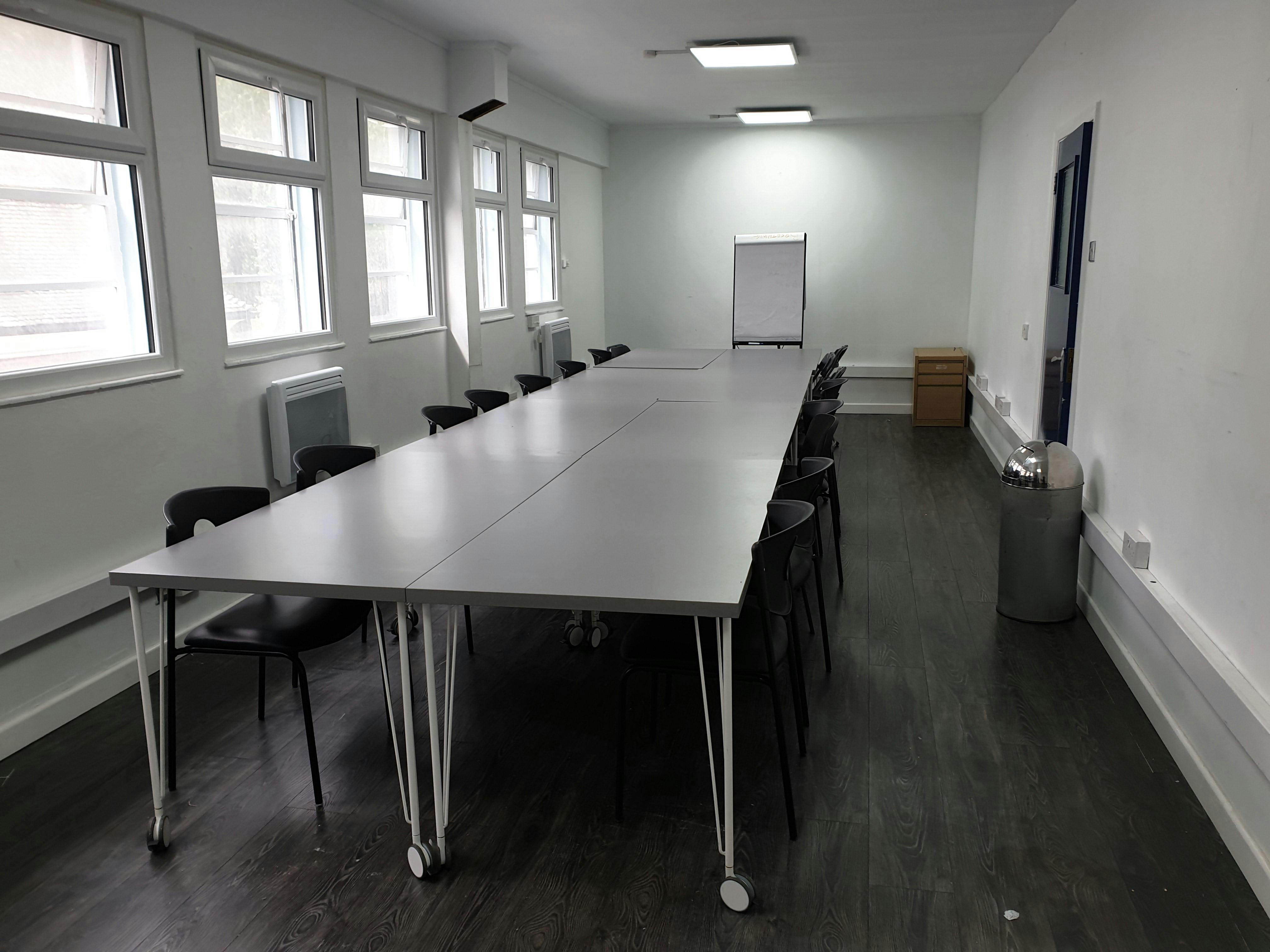 Spacious meeting room with natural light, ideal for training and collaborative sessions.