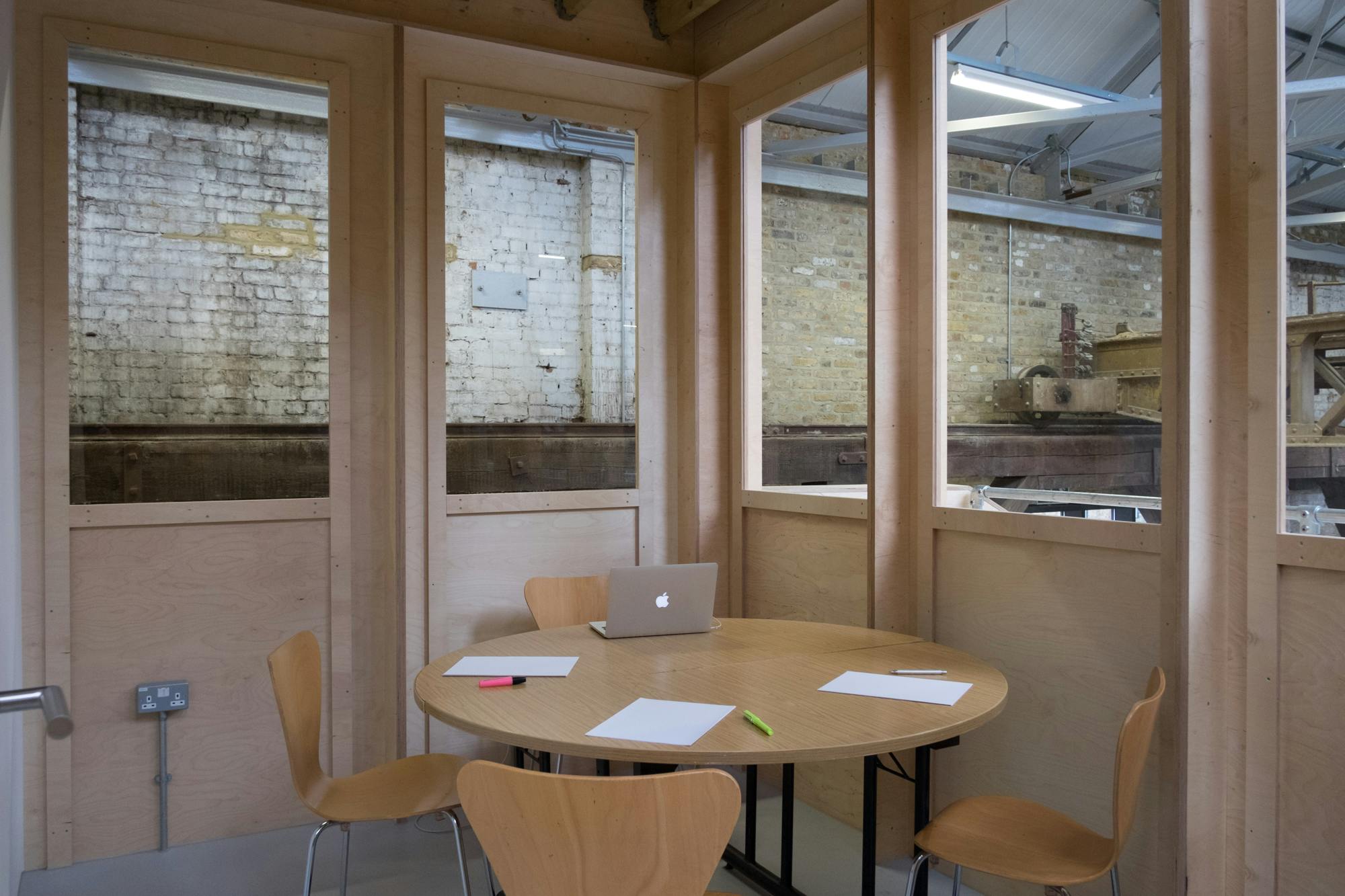 Multipurpose meeting room with round table for intimate brainstorming sessions.