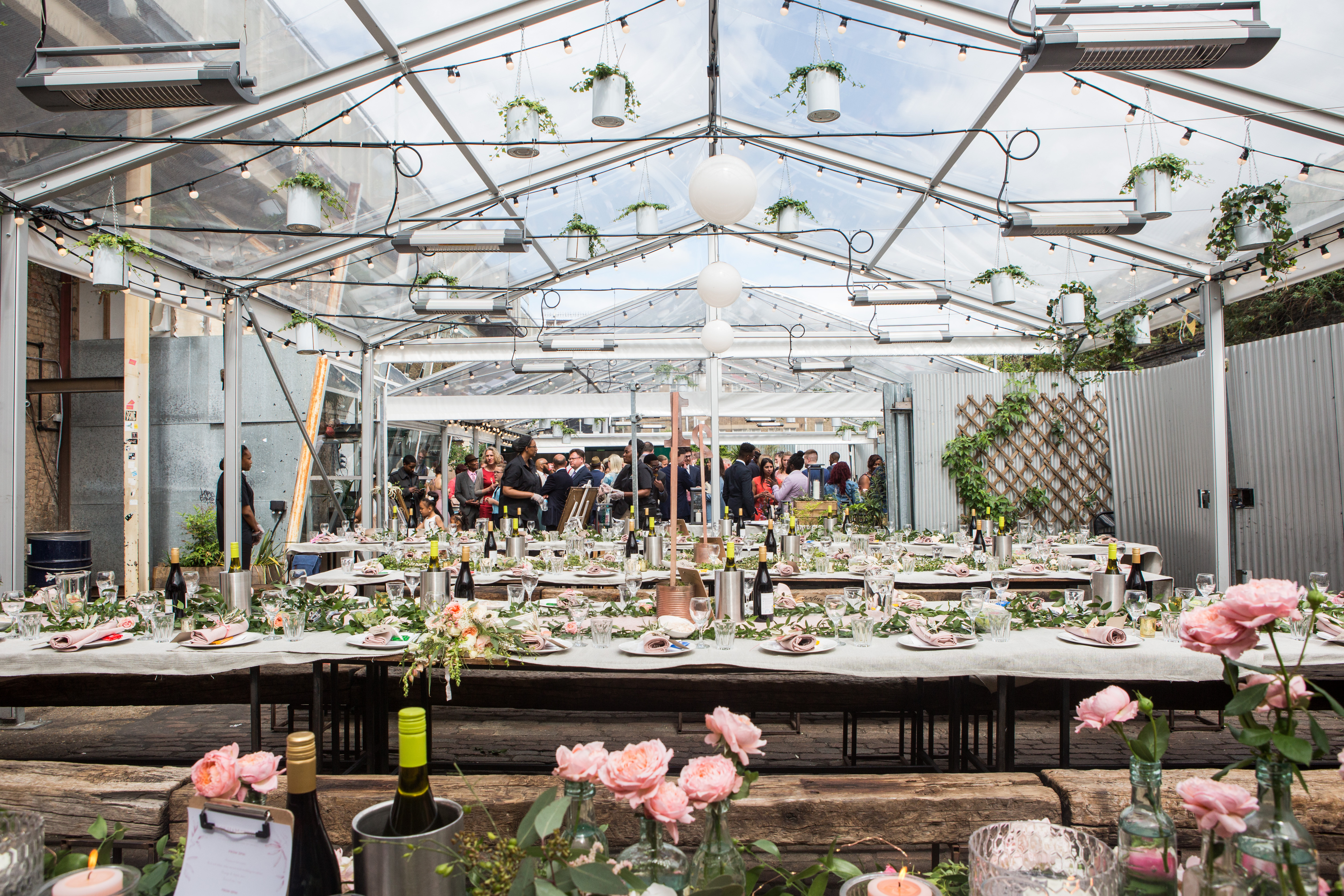Elegant greenhouse event space with floral centerpieces for networking and celebrations. - Banner