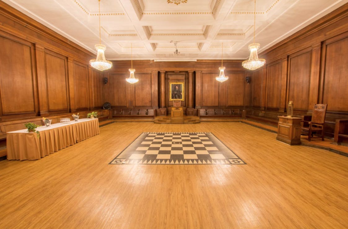 Elegant meeting room at Goulburn Lodge, featuring wooden paneling and chandelier.