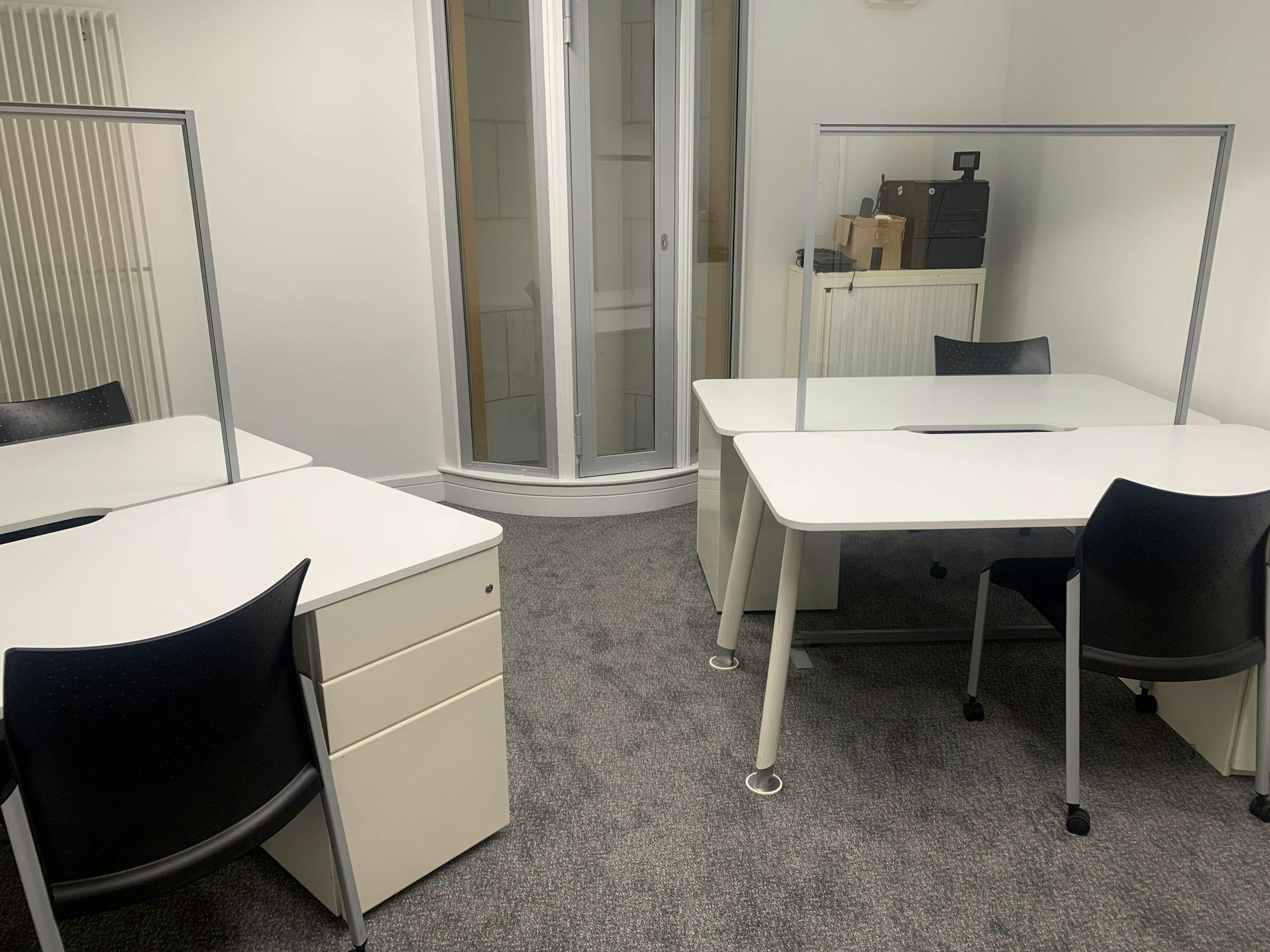 Modern conference hall with desks and dividers for collaborative meetings.