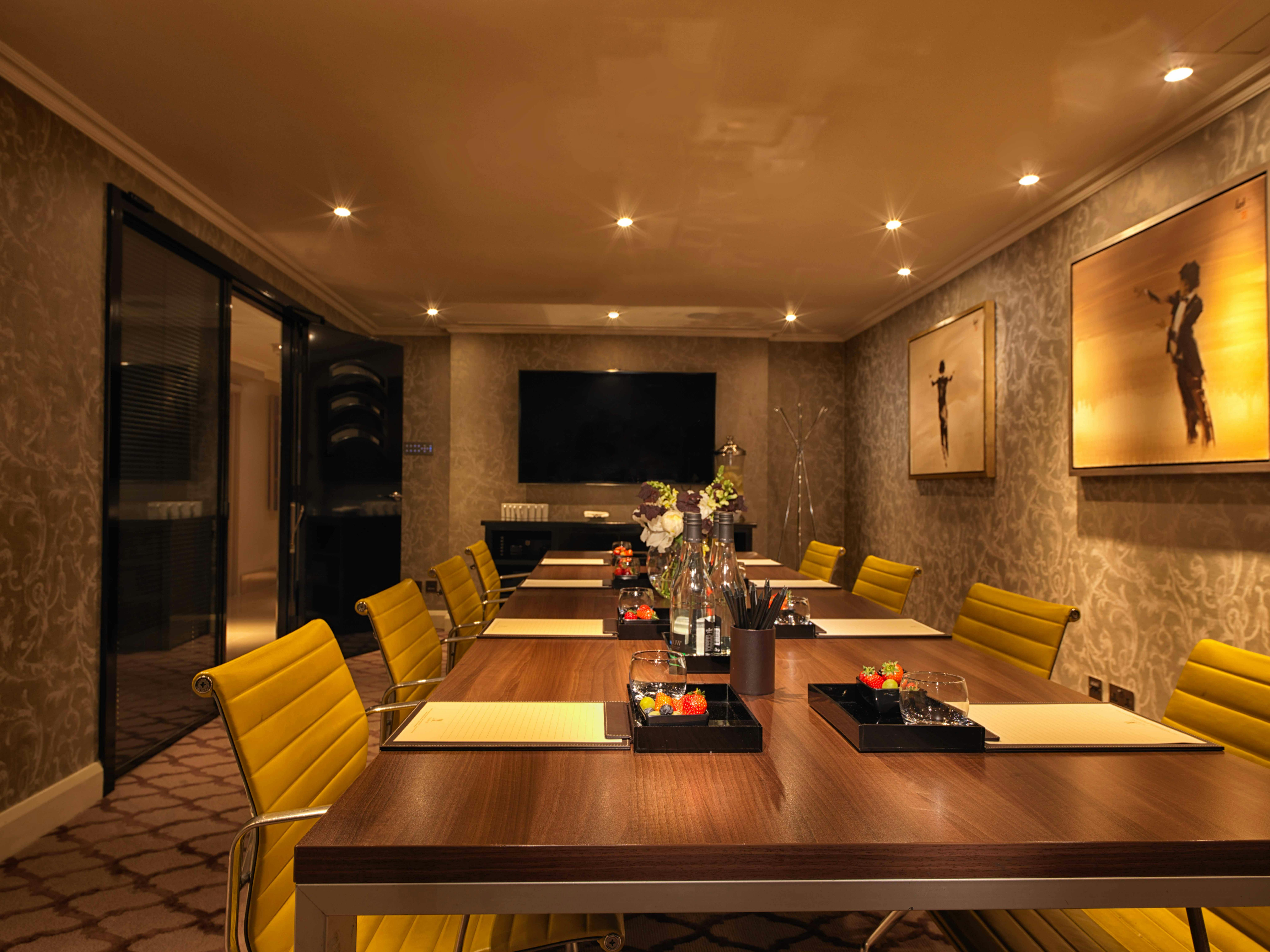Private Suite 9 at The May Fair Hotel, elegant meeting room with wooden table and yellow chairs.