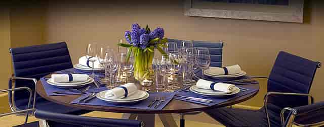 Private Suite 10 dining table with floral centerpiece for upscale corporate events.