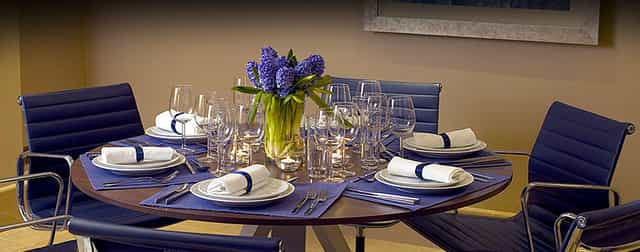Private Suite 10 dining table with floral centerpiece for upscale corporate events.