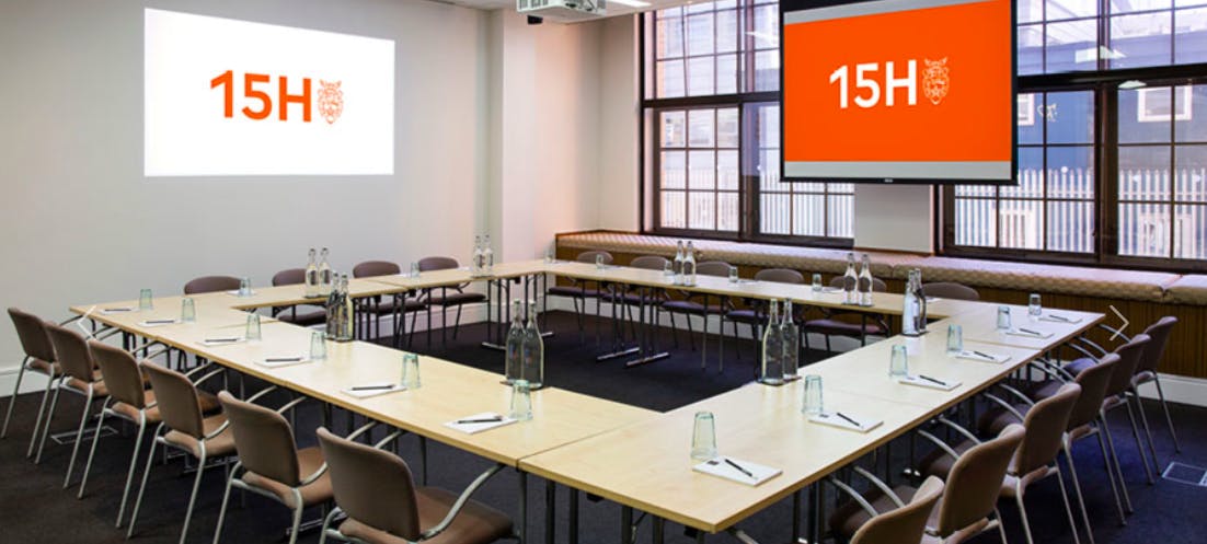 U-shaped meeting room with dual screens for collaborative sessions and effective teamwork.