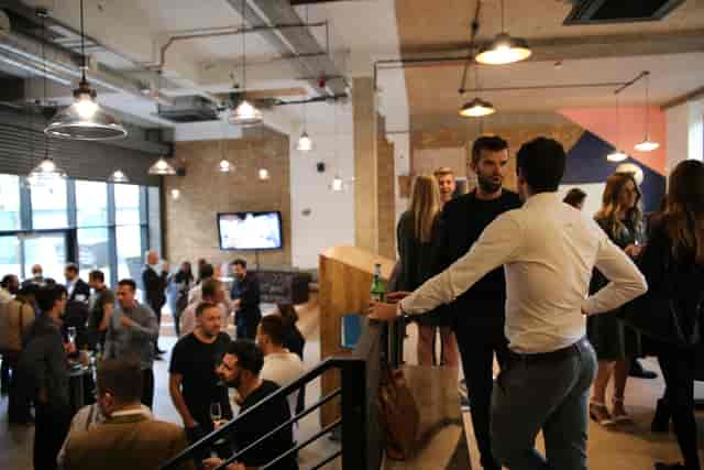 Vibrant networking event in modern venue with engaged crowd and stylish decor.