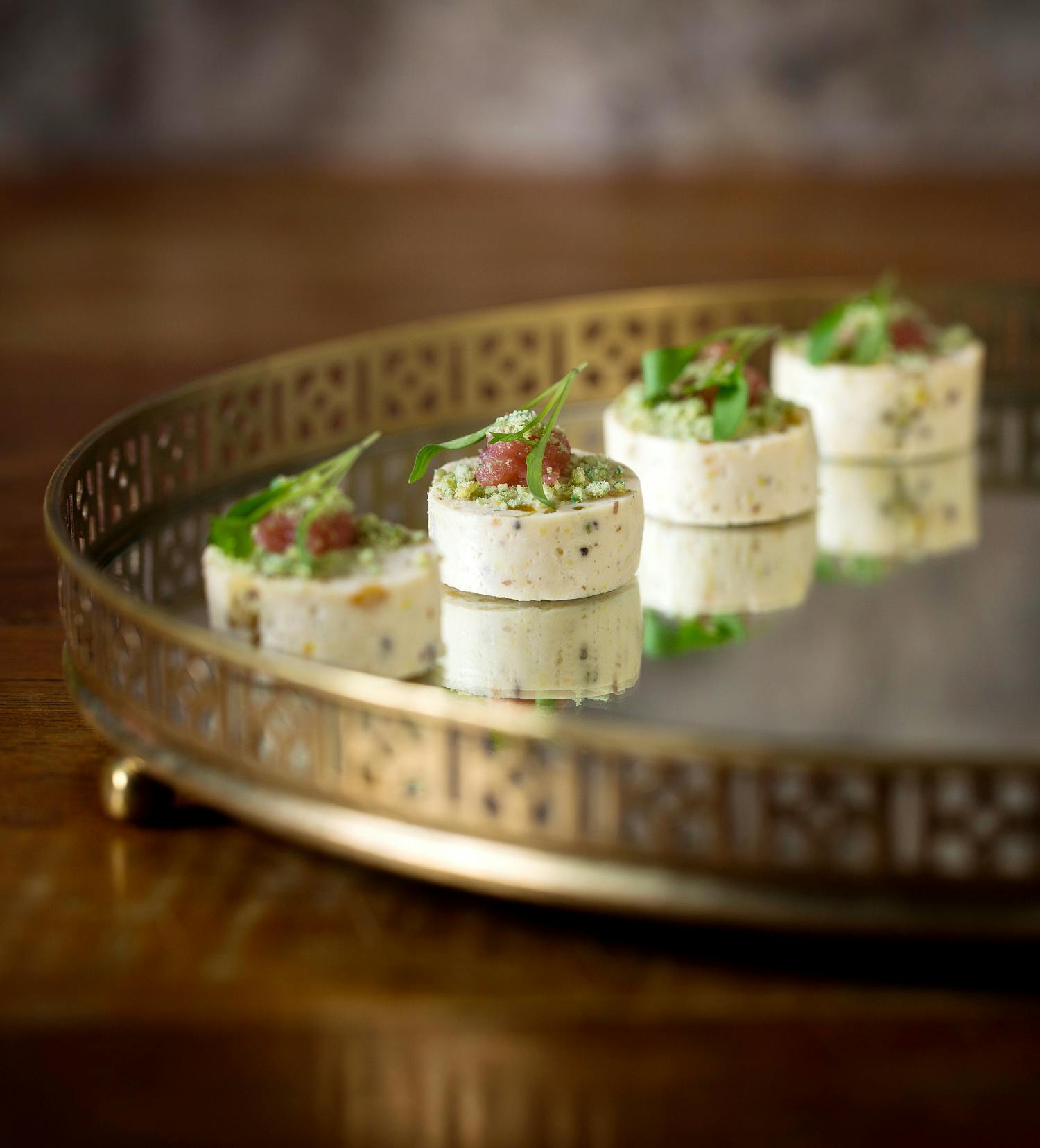 Gourmet hors d'oeuvres on a decorative tray for upscale networking events.