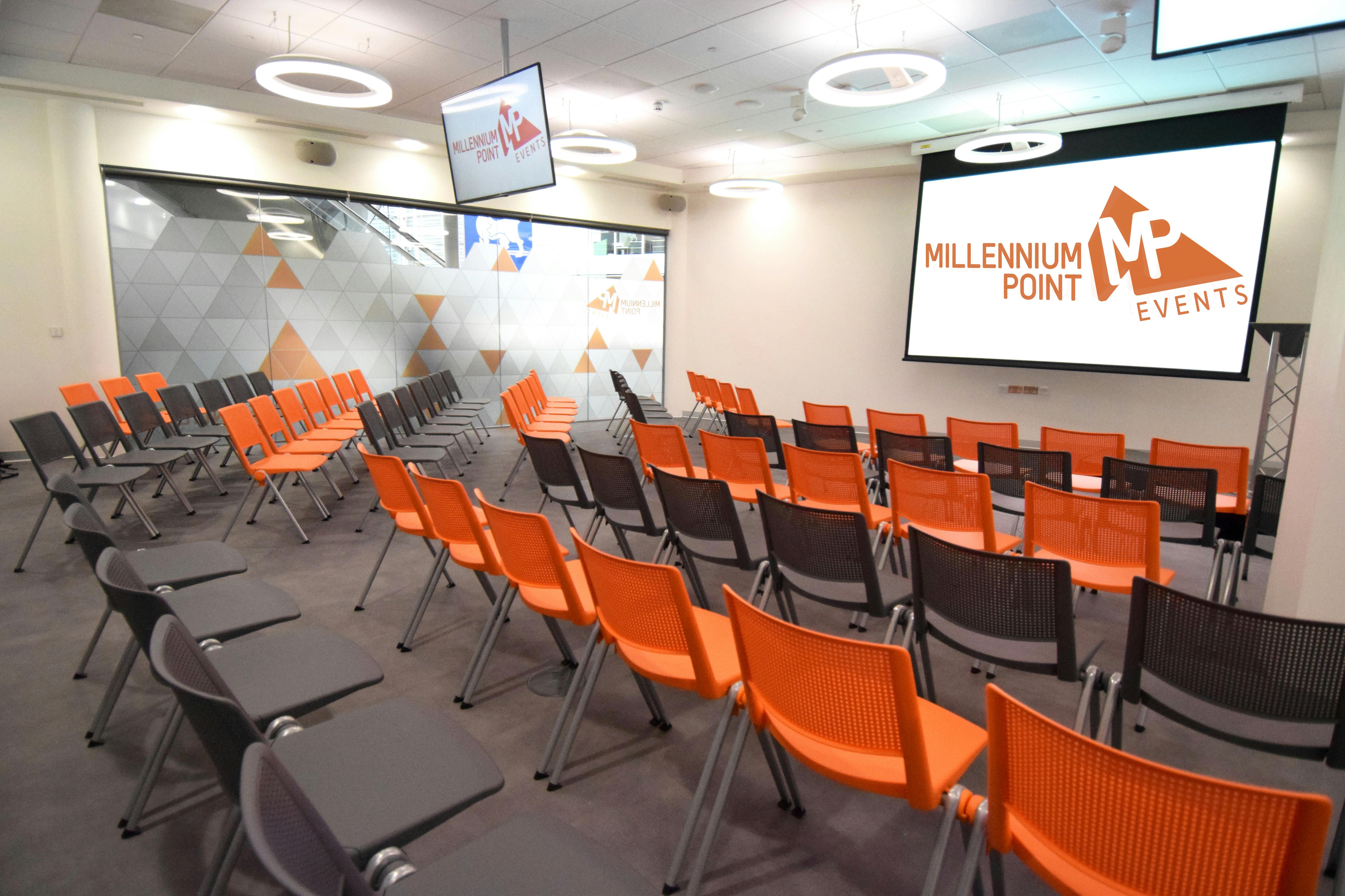 Modern event space with orange chairs, ideal for conferences and workshops at Millennium Point.