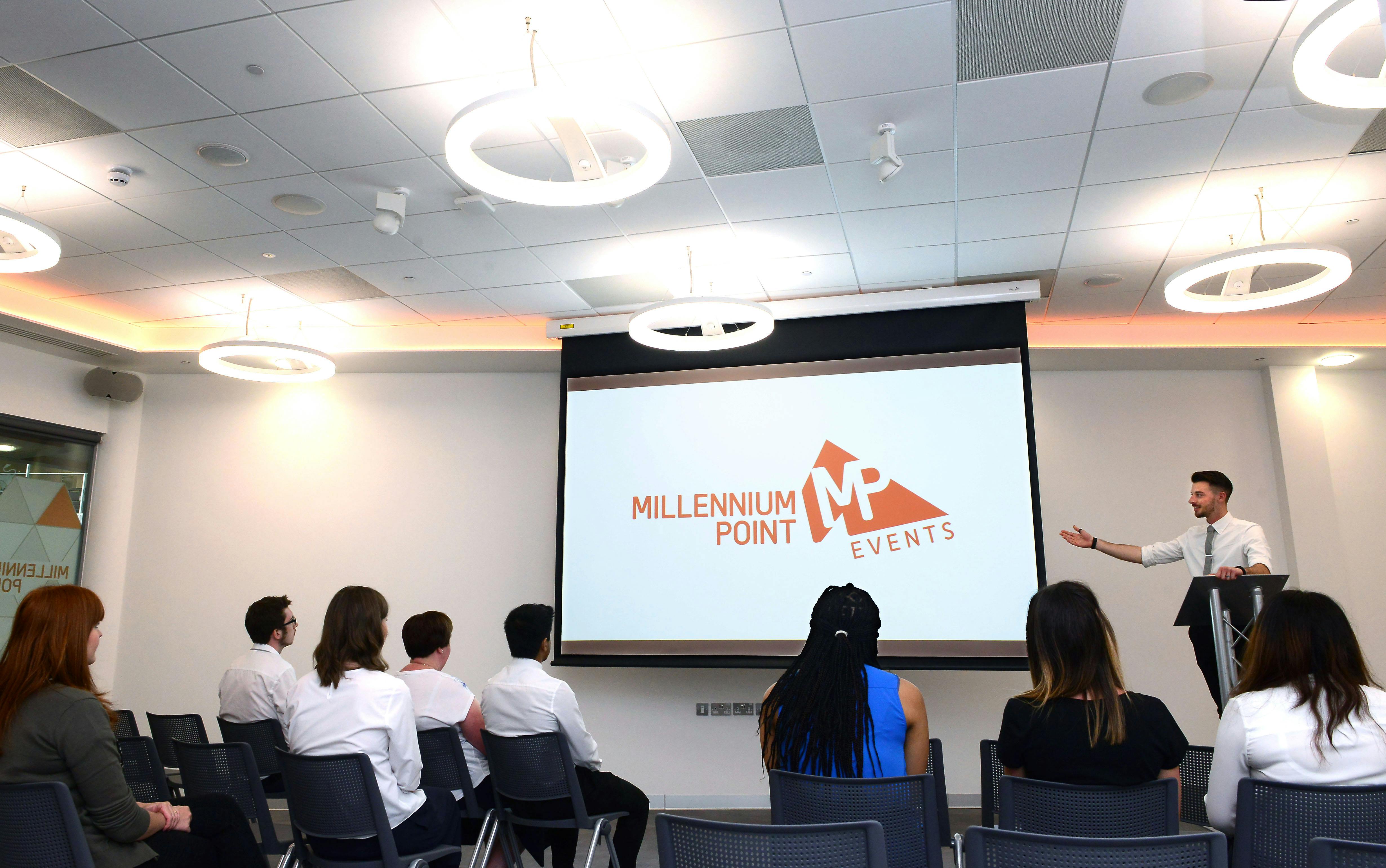 CONNECT Event Space at Millennium Point, featuring a speaker in a modern presentation setting.