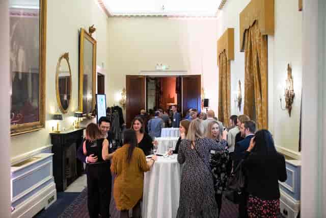 Vibrant networking event at St James Rooms, 116 Pall Mall, with elegant decor and warm lighting.