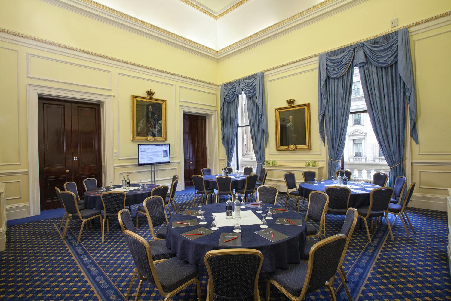 St James Rooms at 116 Pall Mall, elegant meeting space with round tables and natural light.